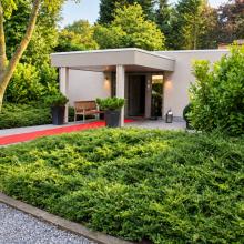 Ingang van One+ Event Place tussen het groen