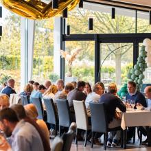 Algemene zaalopstelling met tuinzicht bij Maekelhoeve