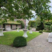 Groene binnentuin met receptietafels bij Pauwkenshof