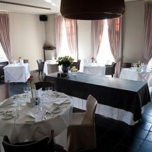 Feestzaal met ronde tafels en gordijnen bij Di Coylde