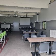 Cafe en ontmoetingsruimte met groene barstoelen