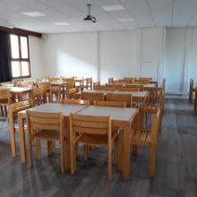 Grote activiteitenzaal met tafels en stoelen