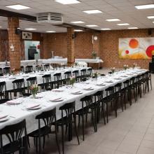 Feestzaal met lange gedekte tafels bij De Ware Vrienden