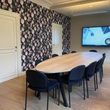 Vergaderruimte Claire met rond overleg en presentatiescherm