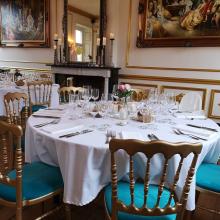 Historisch salon met gedekte ronde tafels en schilderijen