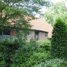 Hoevegebouw omgeven door de groene tuin