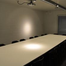 Vergaderlokaal 2 met lange tafel en projector