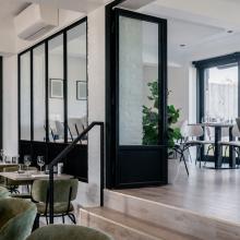 Zithoek met groene stoelen en glazen scheidingswand