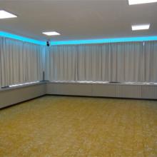 Kleine zaal met gordijnen en blauw lichtaccent