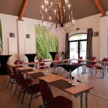 Lichte zaal met kroonluchter en U-vormige tafelindeling