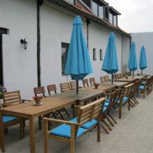 Ter Castaigne, terras met houten tafels en blauwe parasols