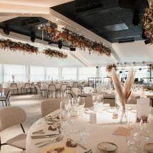 Gedekte ronde tafels en hangende bloemendecoratie in de feestzaal