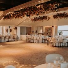 Feestzaal met vrije dansvloer en gedekte ronde tafels