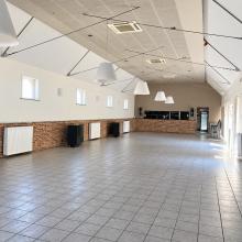 Lichte zaal met bakstenen lambrisering en bar
