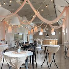 Zaal in receptieopstelling met statafels en lichtslingers